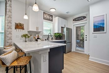 A kitchen with a white counter top and a refrigerator.